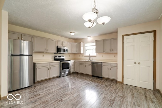 12157 Longstraw Dr, Indianapolis, IN 46236 - kitchen featuring appliances with stainless steel finishes, a chandelier, a sink, light countertops, and a textured ceiling