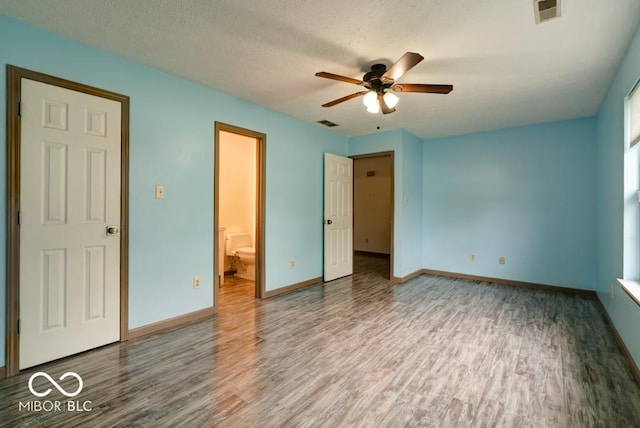 12157 Longstraw Dr, Indianapolis, IN 46236 - unfurnished bedroom with wood finished floors, baseboards, ensuite bathroom, a textured ceiling, and a ceiling fan