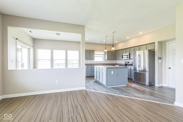 9692 Centennial Ct, Avon, IN 46123 - kitchen featuring appliances with stainless steel finishes, baseboards, wood finished floors, recessed lighting, and a textured ceiling