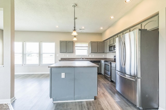 9692 Centennial Ct, Avon, IN 46123 - kitchen with appliances with stainless steel finishes, a textured ceiling, dark wood-type flooring, recessed lighting, and a center island