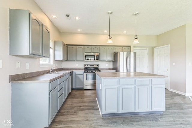 9692 Centennial Ct, Avon, IN 46123 - kitchen featuring appliances with stainless steel finishes, a center island, light wood-style floors, recessed lighting, and pendant lighting