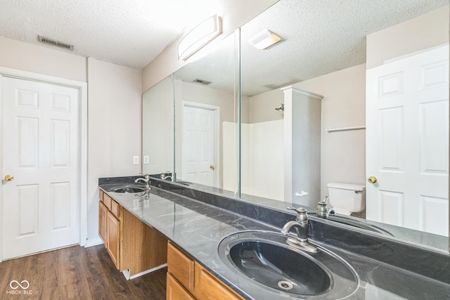 9692 Centennial Ct, Avon, IN 46123 - bathroom with a textured ceiling, wood finished floors, toilet, and double vanity