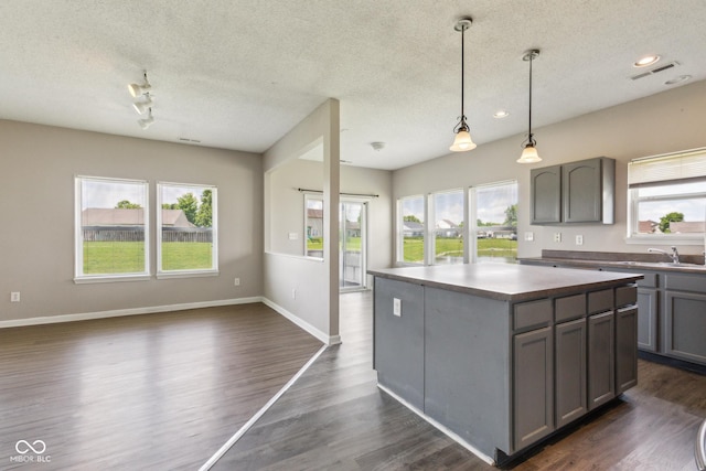 9692 Centennial Ct, Avon, IN 46123 - kitchen featuring a textured ceiling, gray cabinets, healthy amount of natural light, open floor plan, and a kitchen island
