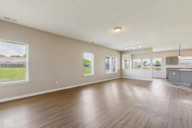 9692 Centennial Ct, Avon, IN 46123 - unfurnished living room featuring dark wood-style floors, a textured ceiling, and baseboards