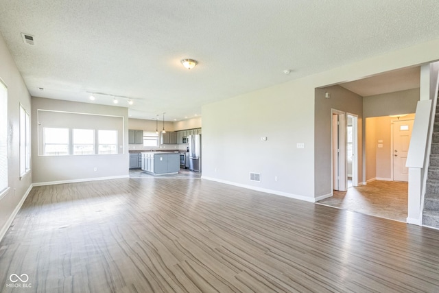 9692 Centennial Ct, Avon, IN 46123 - unfurnished living room featuring wood finished floors, a textured ceiling, and baseboards