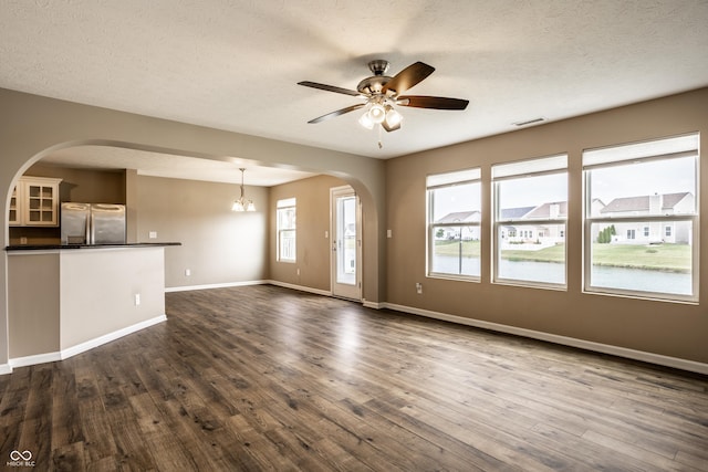 6114 Pebblebrooke Rd, Whitestown, IN 46075 - unfurnished living room with arched walkways, dark wood-style floors, baseboards, and a textured ceiling
