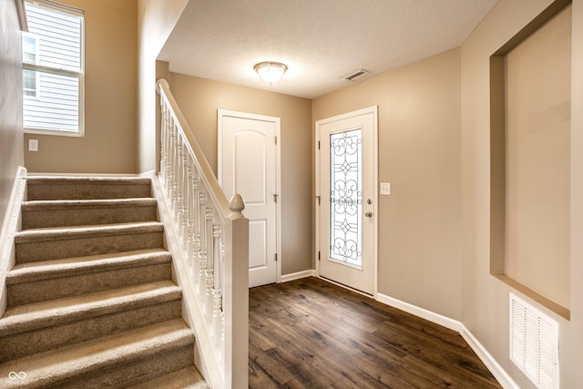 6114 Pebblebrooke Rd, Whitestown, IN 46075 - foyer featuring dark wood-style flooring, stairs, baseboards, and a textured ceiling
