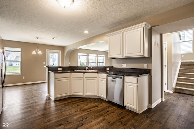 6114 Pebblebrooke Rd, Whitestown, IN 46075 - kitchen with stainless steel appliances, a sink, a peninsula, a textured ceiling, and arched walkways