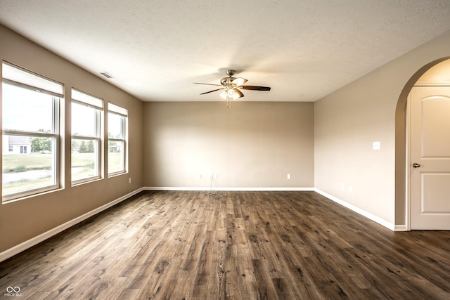 6114 Pebblebrooke Rd, Whitestown, IN 46075 - unfurnished room featuring ceiling fan, dark wood-type flooring, arched walkways, baseboards, and a textured ceiling