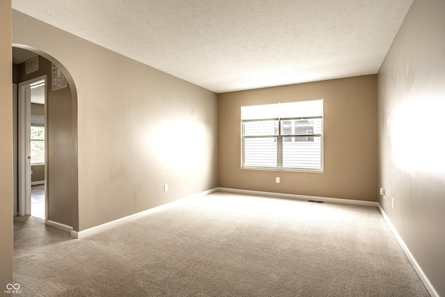 6114 Pebblebrooke Rd, Whitestown, IN 46075 - carpeted empty room with arched walkways, a textured ceiling, and baseboards