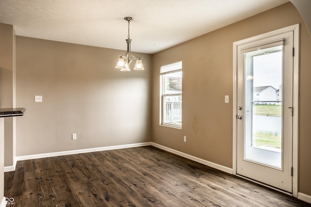 6114 Pebblebrooke Rd, Whitestown, IN 46075 - unfurnished dining area featuring dark wood-type flooring, baseboards, and a chandelier