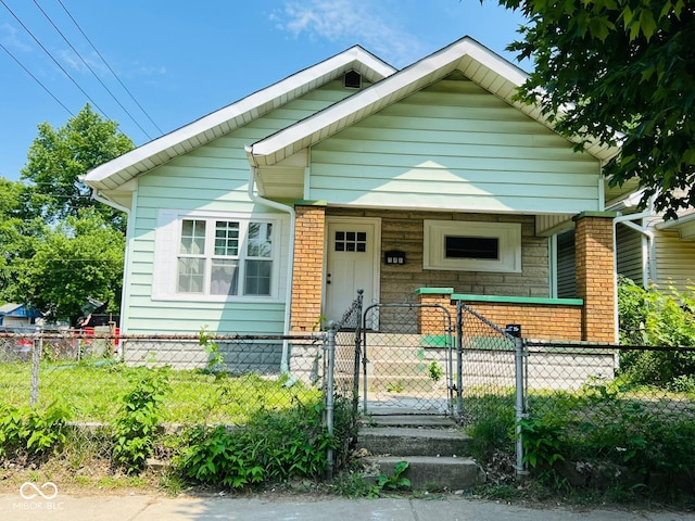 547 N Livingston Ave, Indianapolis, IN 46222 - bungalow-style house with a porch, a fenced front yard, and brick siding