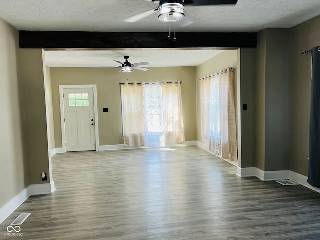547 N Livingston Ave, Indianapolis, IN 46222 - unfurnished living room featuring ceiling fan, a textured ceiling, beamed ceiling, wood finished floors, and baseboards