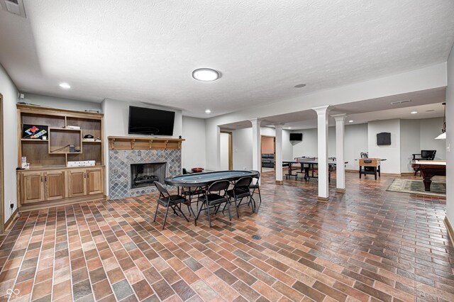 4181 Whitetail Woods Dr, Bargersville, IN 46106 - dining space featuring a fireplace, ornate columns, brick flooring, recessed lighting, and a textured ceiling