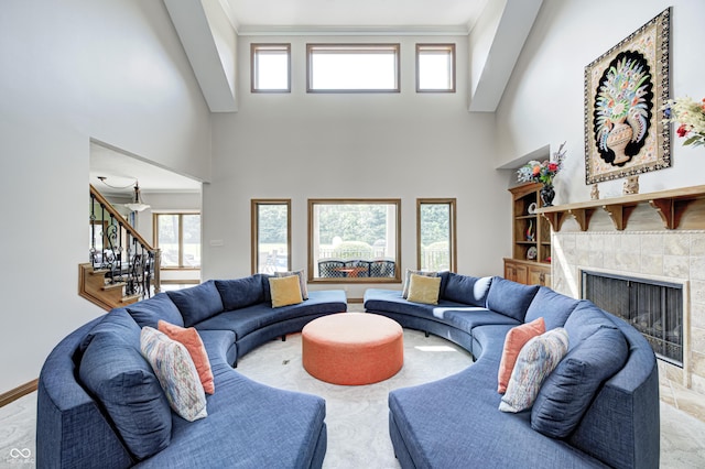 4181 Whitetail Woods Dr, Bargersville, IN 46106 - living room with stairs, a tiled fireplace, a towering ceiling, healthy amount of natural light, and ornamental molding