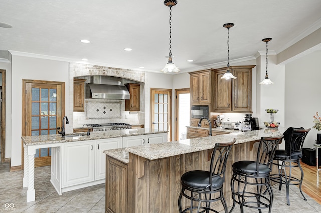 4181 Whitetail Woods Dr, Bargersville, IN 46106 - kitchen featuring a sink, wall chimney range hood, ornamental molding, a center island, and a kitchen breakfast bar