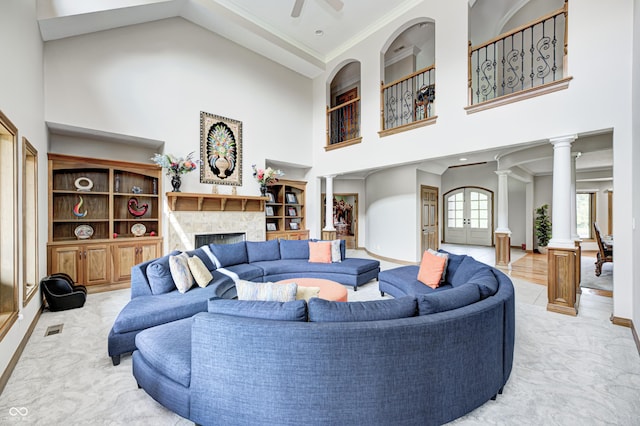 4181 Whitetail Woods Dr, Bargersville, IN 46106 - living room featuring a towering ceiling, decorative columns, a fireplace, ceiling fan, and crown molding