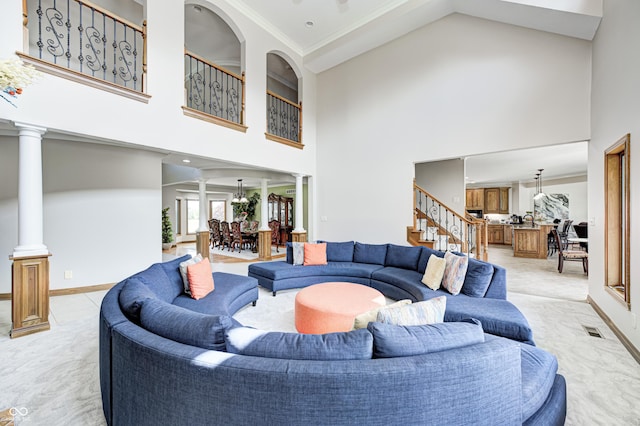 4181 Whitetail Woods Dr, Bargersville, IN 46106 - living room featuring decorative columns, a towering ceiling, light colored carpet, stairway, and baseboards