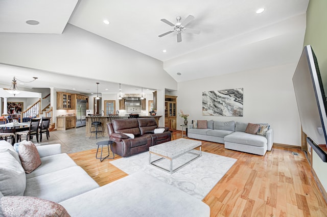 4181 Whitetail Woods Dr, Bargersville, IN 46106 - living room with stairs, a ceiling fan, recessed lighting, high vaulted ceiling, and light wood finished floors