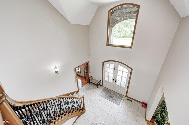 4181 Whitetail Woods Dr, Bargersville, IN 46106 - foyer entrance featuring french doors, light tile patterned floors, baseboards, vaulted ceiling, and arched walkways