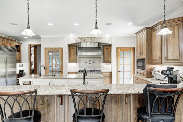 4181 Whitetail Woods Dr, Bargersville, IN 46106 - kitchen with wall chimney range hood, a kitchen island with sink, built in appliances, decorative backsplash, and light stone counters