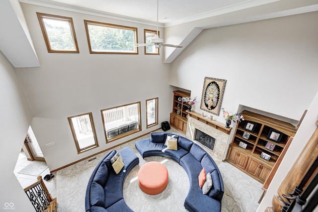 4181 Whitetail Woods Dr, Bargersville, IN 46106 - carpeted living room featuring a fireplace, a ceiling fan, ornamental molding, a towering ceiling, and baseboards