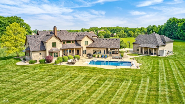 4181 Whitetail Woods Dr, Bargersville, IN 46106 - rear view of property featuring stone siding, a yard, a patio area, an outdoor pool, and an outdoor structure