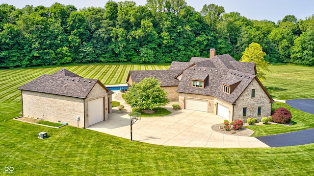 4181 Whitetail Woods Dr, Bargersville, IN 46106 - view of front of house with stone siding, a front yard, concrete driveway, and a chimney