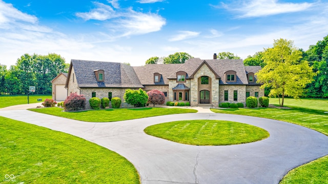 4181 Whitetail Woods Dr, Bargersville, IN 46106 - french country style house featuring stone siding, curved driveway, a front lawn, and a chimney
