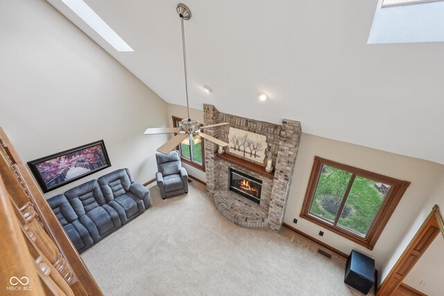 6983 White Oak Dr, Avon, IN 46123 - living room with a skylight, carpet flooring, a brick fireplace, vaulted ceiling, and ceiling fan