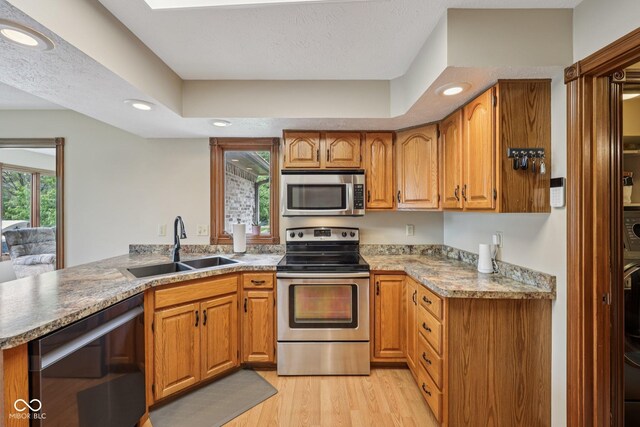 6983 White Oak Dr, Avon, IN 46123 - kitchen with stainless steel appliances, a sink, brown cabinetry, light wood-style floors, and recessed lighting