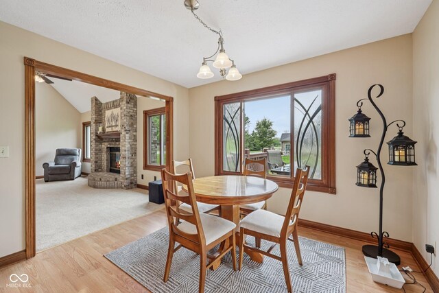 6983 White Oak Dr, Avon, IN 46123 - dining room with baseboards, light wood-style floors, and a fireplace
