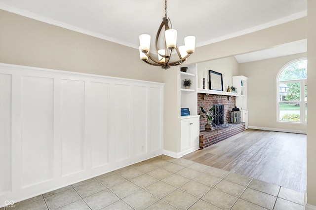 7430 Railway Ct, Indianapolis, IN 46256 - unfurnished dining area featuring a chandelier, a brick fireplace, ornamental molding, a decorative wall, and baseboards