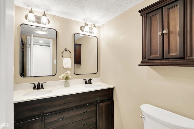 7430 Railway Ct, Indianapolis, IN 46256 - bathroom with double vanity, a textured ceiling, and toilet