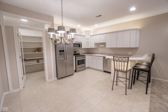 1188 Old Eagle Way, Greenwood, IN 46143 - kitchen with appliances with stainless steel finishes, a chandelier, a sink, light countertops, and white cabinetry