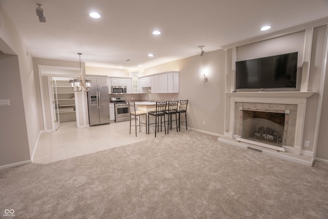 1188 Old Eagle Way, Greenwood, IN 46143 - kitchen with stainless steel appliances, a chandelier, a kitchen breakfast bar, light colored carpet, and baseboards