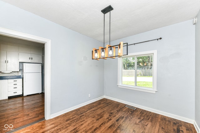 402 E 4th St, Sheridan, IN 46069 - spare room featuring baseboards, dark wood-type flooring, a chandelier, and a textured ceiling