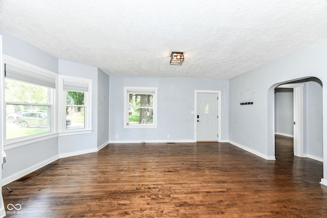 402 E 4th St, Sheridan, IN 46069 - foyer featuring arched walkways, a textured ceiling, dark wood-style floors, and baseboards