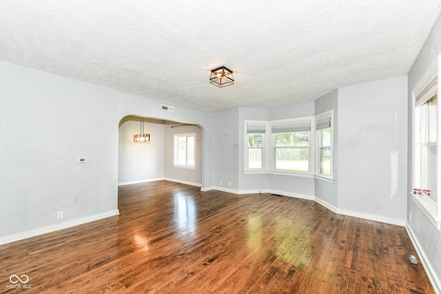 402 E 4th St, Sheridan, IN 46069 - empty room with arched walkways, wood finished floors, a textured ceiling, and baseboards