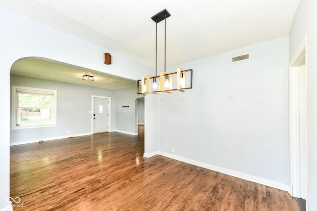402 E 4th St, Sheridan, IN 46069 - empty room with arched walkways, dark wood-style floors, baseboards, and a chandelier