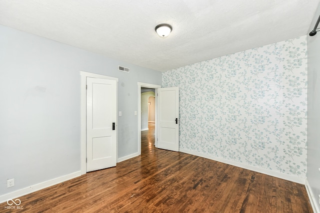402 E 4th St, Sheridan, IN 46069 - empty room with wallpapered walls, wood finished floors, baseboards, and a textured ceiling