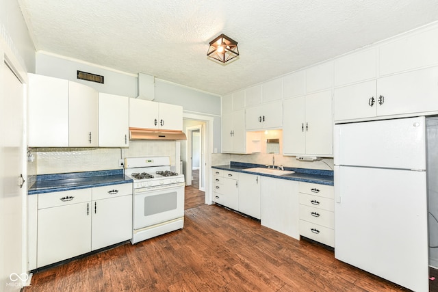 402 E 4th St, Sheridan, IN 46069 - kitchen with white appliances, under cabinet range hood, a sink, dark countertops, and a textured ceiling