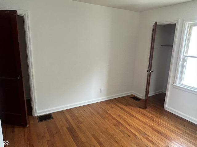 330 S Butler Ave, Indianapolis, IN 46219 - unfurnished bedroom featuring a closet, a spacious closet, and wood finished floors