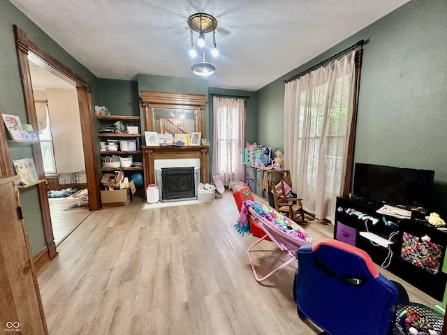 211 6th St, Covington, IN 47932 - living area with a fireplace, wood finished floors, and a textured ceiling