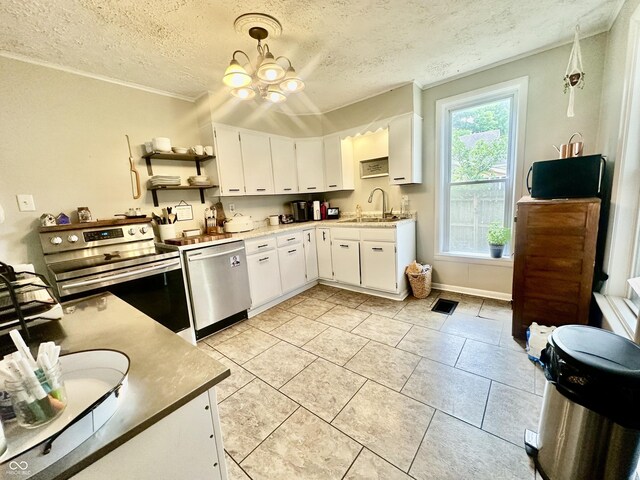 211 6th St, Covington, IN 47932 - kitchen with stainless steel appliances, a sink, a textured ceiling, white cabinets, and ornamental molding