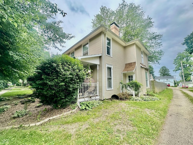 211 6th St, Covington, IN 47932 - view of side of property with a chimney and covered porch
