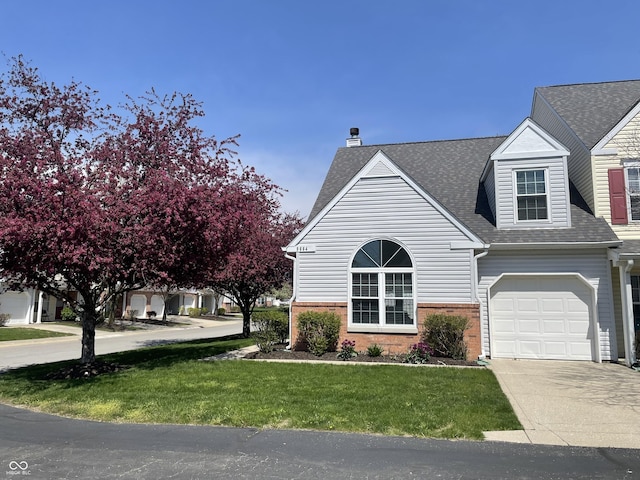 9664 Legare St Unit 2601, Fishers, IN 46038 - view of front facade with a chimney, roof with shingles, concrete driveway, a front lawn, and brick siding