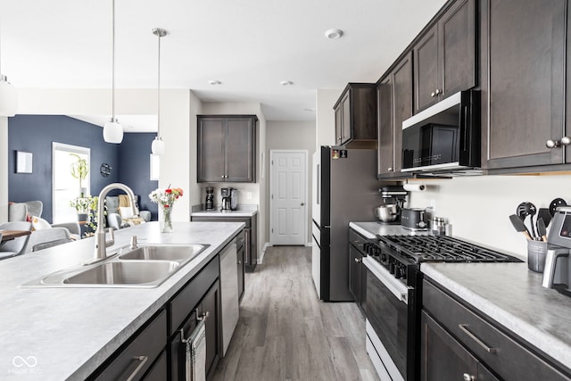 6305 N Woodhaven Dr, Mccordsville, IN 46055 - kitchen with appliances with stainless steel finishes, a sink, light wood finished floors, and dark brown cabinets