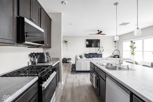 6305 N Woodhaven Dr, Mccordsville, IN 46055 - kitchen featuring dishwasher, gas stove, stainless steel microwave, a sink, and wood finished floors