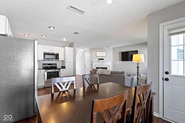 603 Daviess Dr, Westfield, IN 46074 - dining space featuring dark wood-style flooring, a tiled fireplace, and recessed lighting